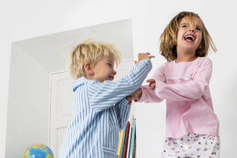 Young Boy and Girl laughing and playing inside