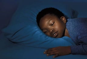 A Young Boy sleeping on his bed