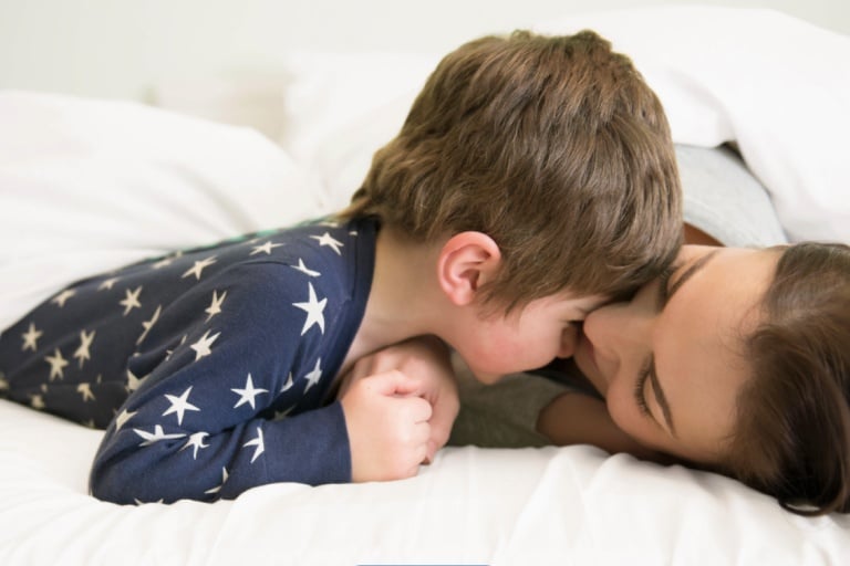 madre e hijo en pijama acostado en la cama